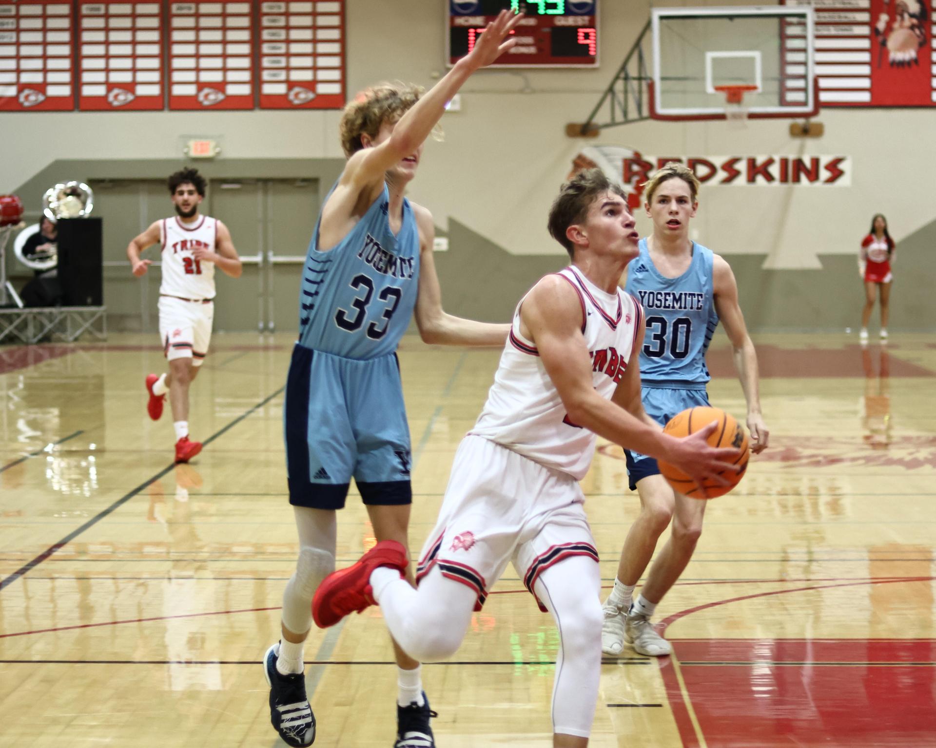 Varsity boys playing basketball against yosemite
