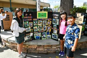 Three students pose next to their Action Team Display trifold.