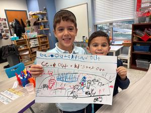 two boys holding up their fire safety poster