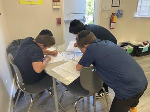 3 eighth grade boys working together.