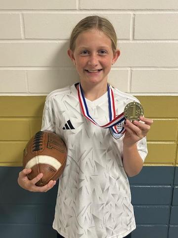 pic of a girl wearing a medal and holding a football