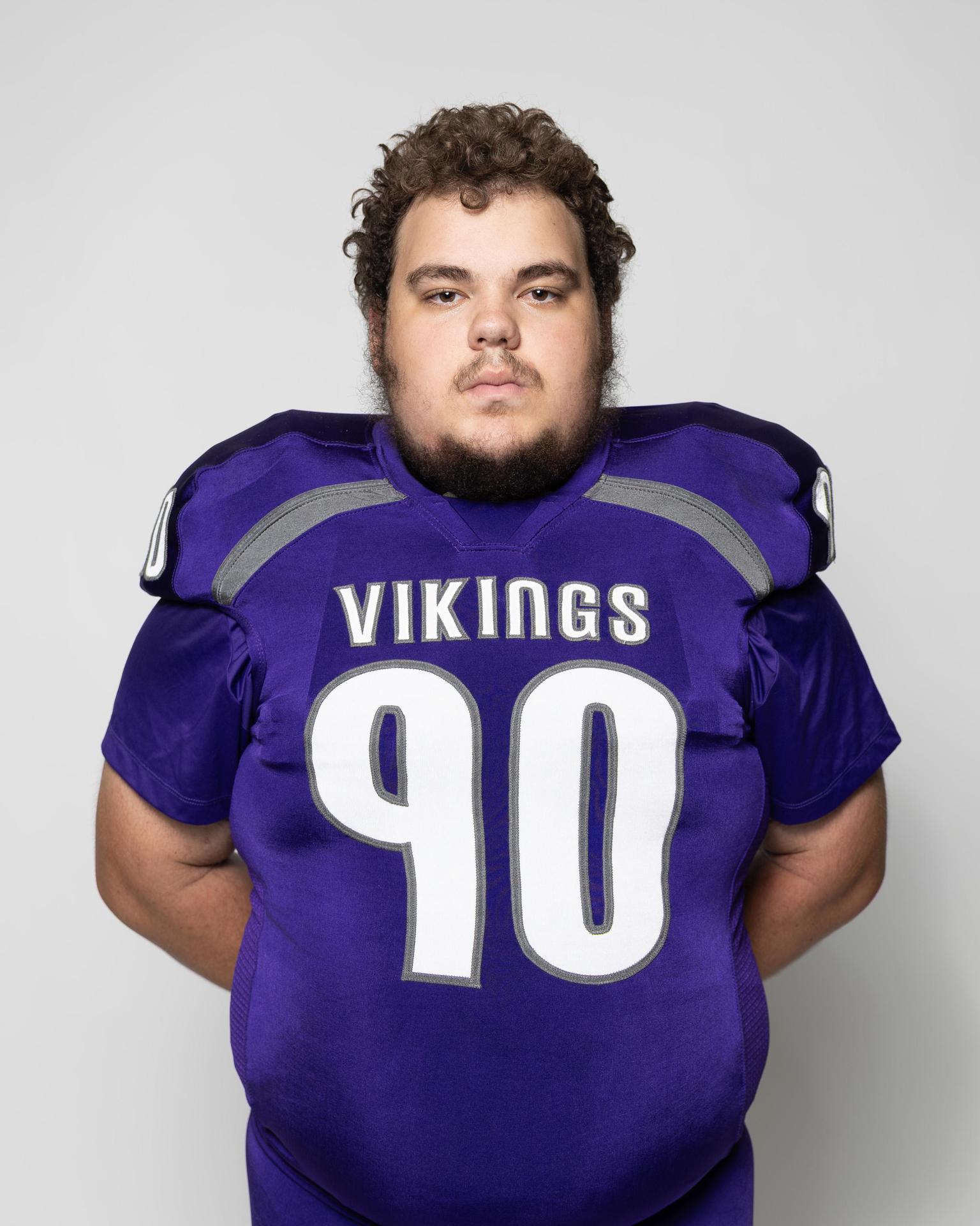 Football player in a purple jersey with the number 90 and Vikings lettering.