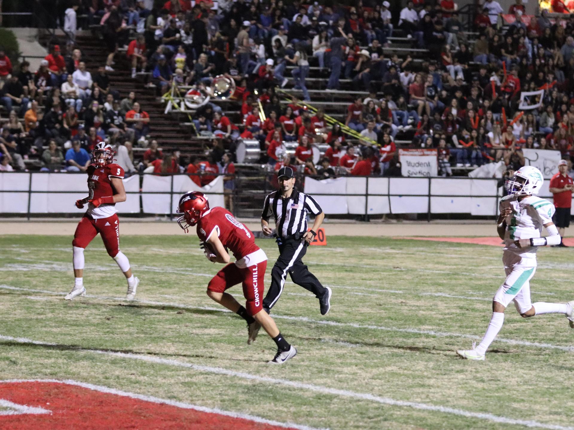 varsity football players in action against Riverdale
