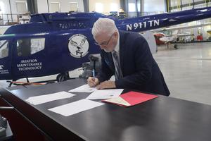 Superintendent Richard Mertin signs Airframe certificate paperwork