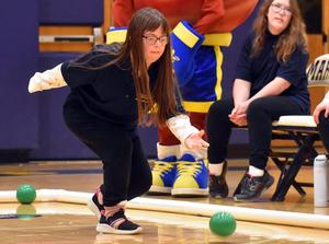 a girl rolling a bocce ball