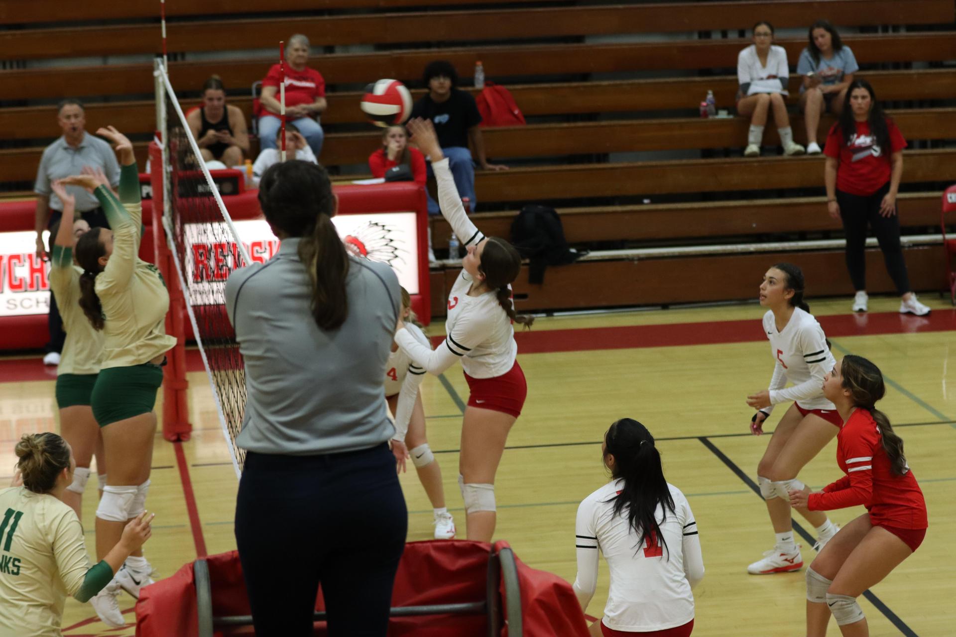 varsity volleyball players in action against liberty