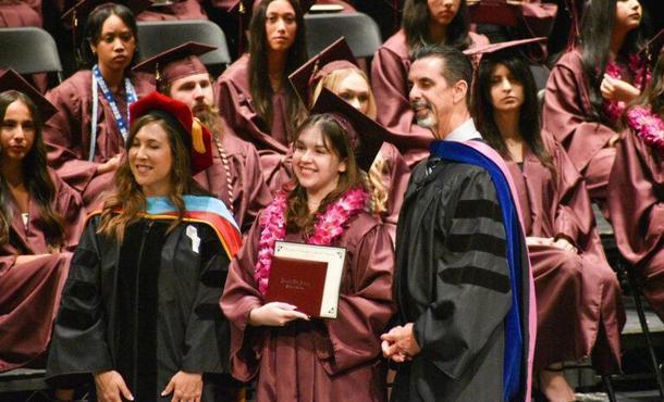 A group of students in burgundy caps and gowns at the Learning Post Academy graduation ceremony.