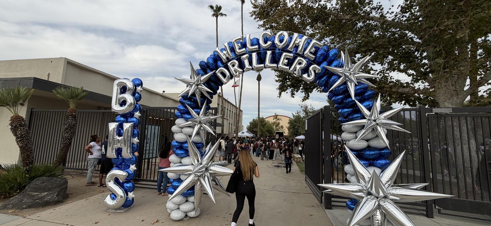 Archway decorated with balloons welcoming students to an event.