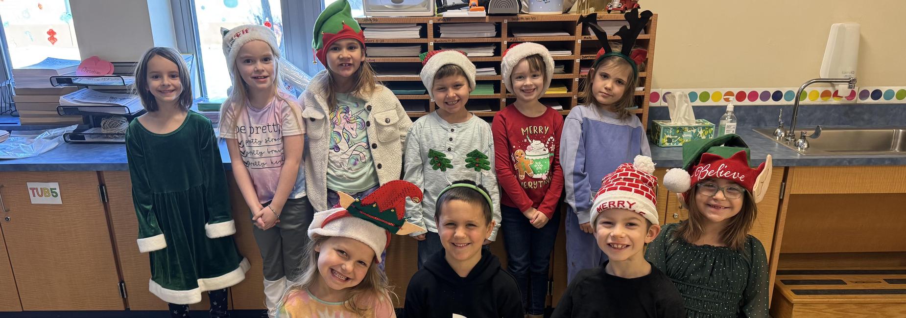 Group of students smiling wearing holiday hats