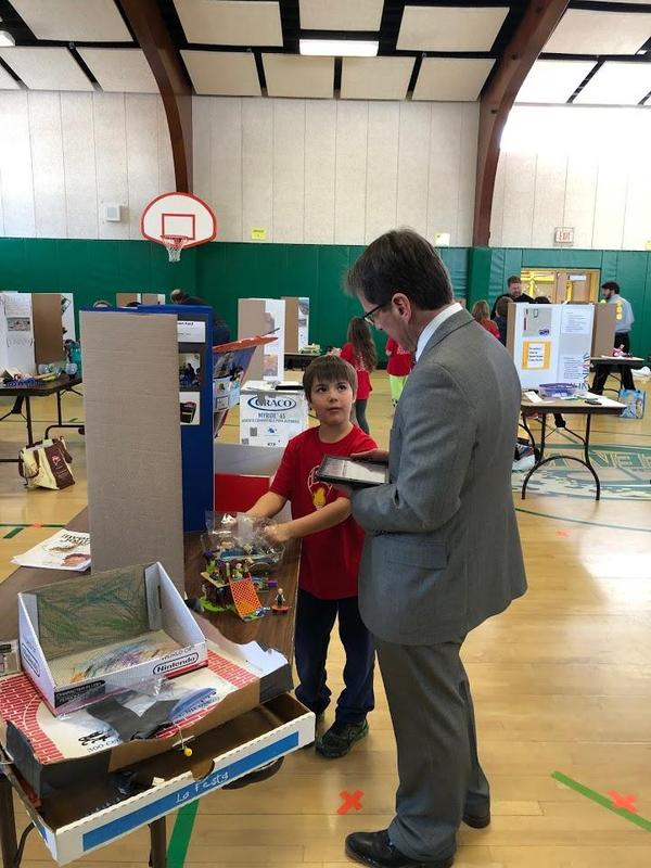 Young Inventors NH Commissioner of Education, Frank Edelblut Judging a students presentation.