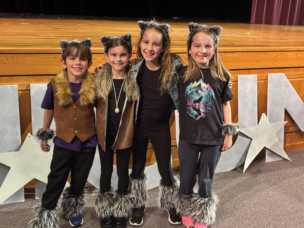 Four students wearing cat costumes.