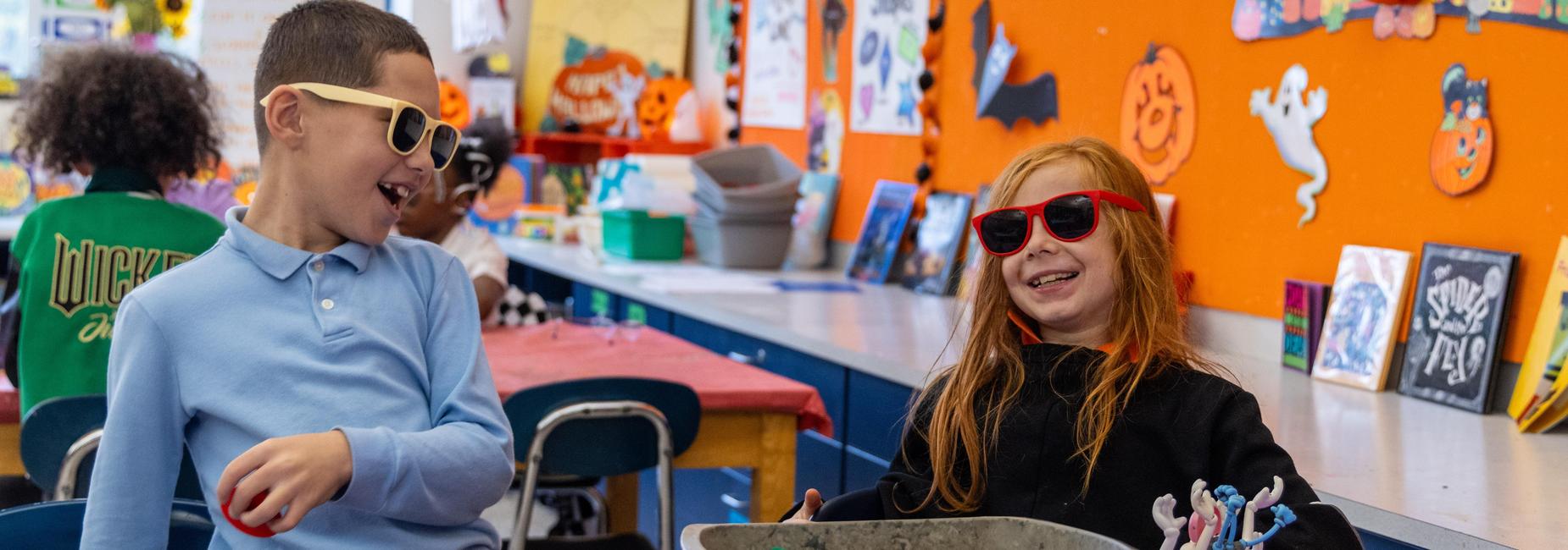 Two elementary students laugh while working on an art project