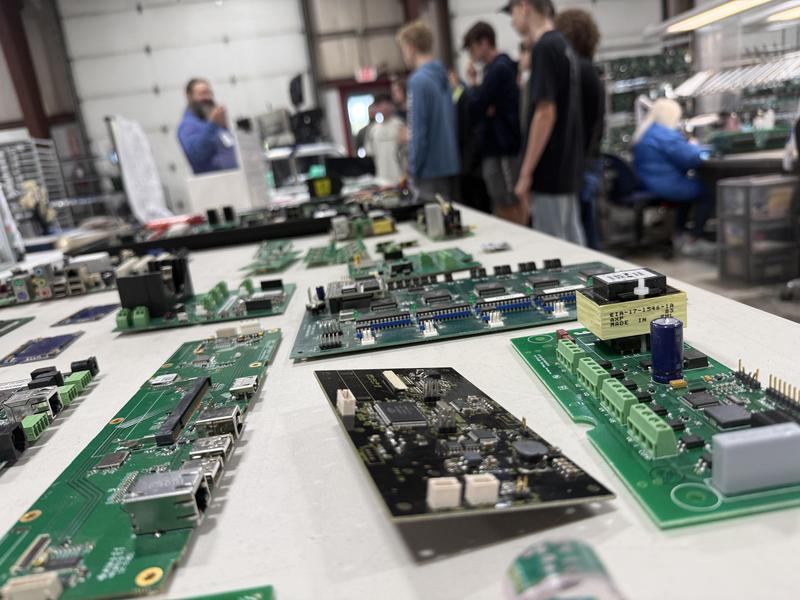 close up of computer parts with students in background