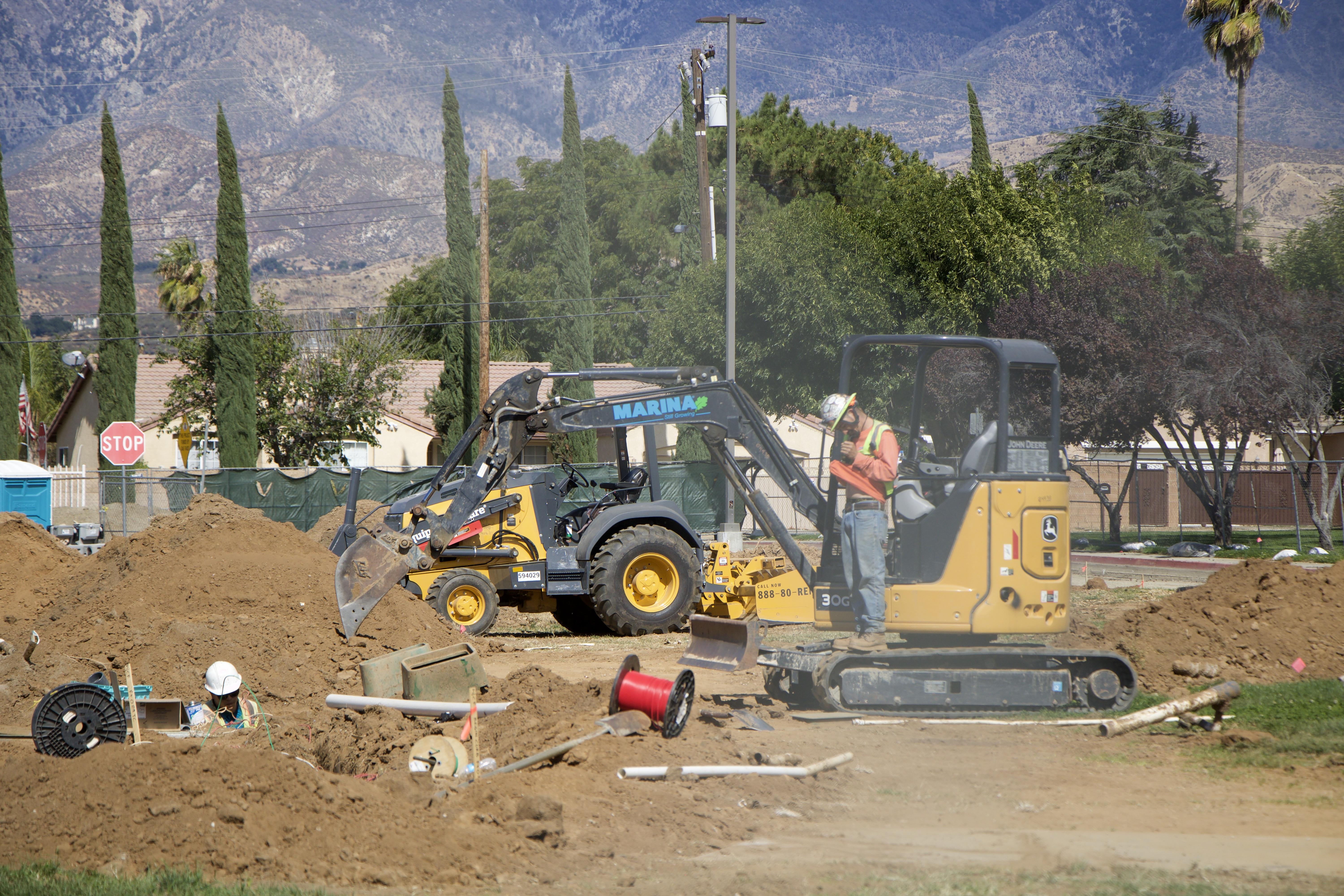 Heavy construction machinery on a dirt patch.