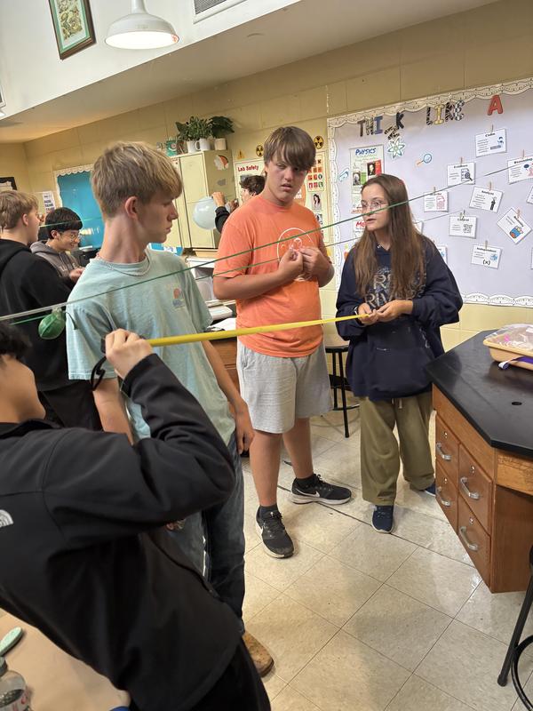 Students holding string taut  for experiment
