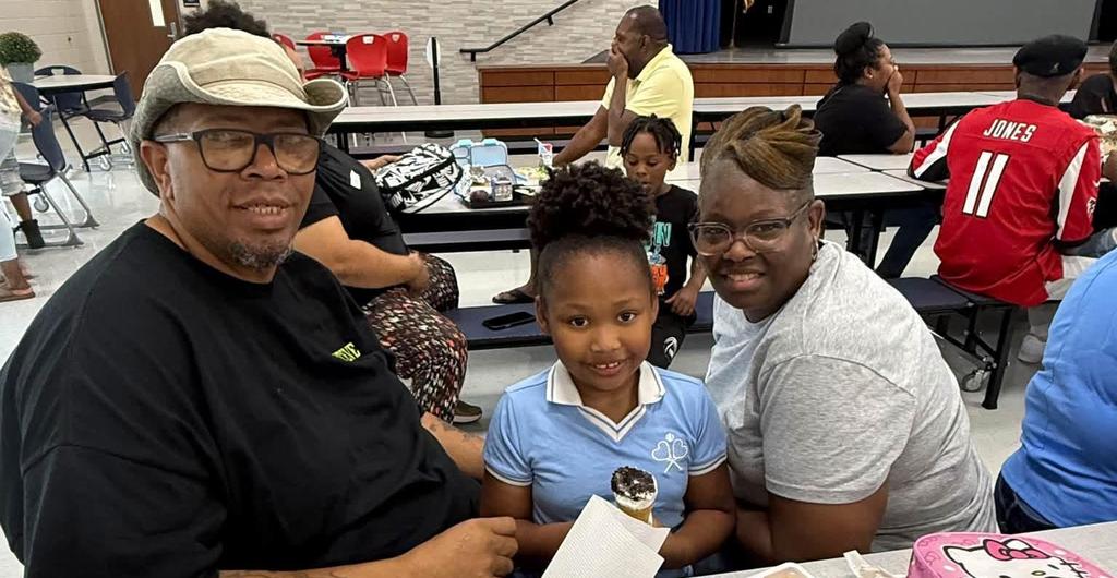 Student eating with family for grandparent's lunch