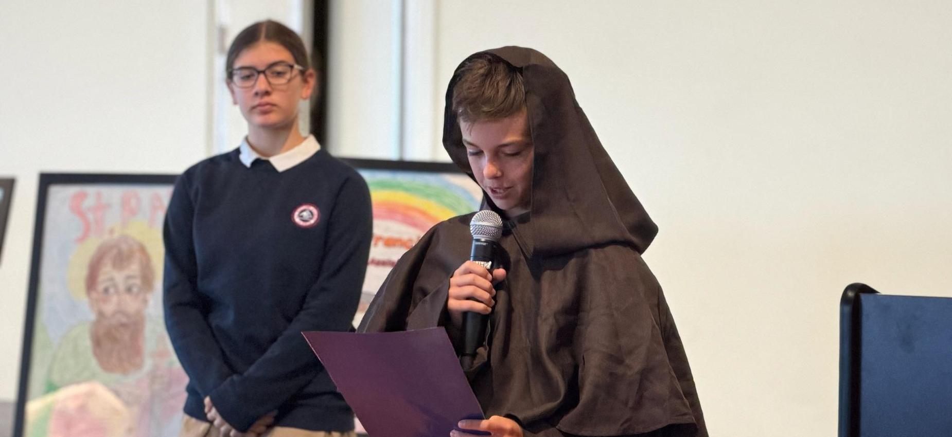 6th grade student dressed as St. Francis presents about the saints life.