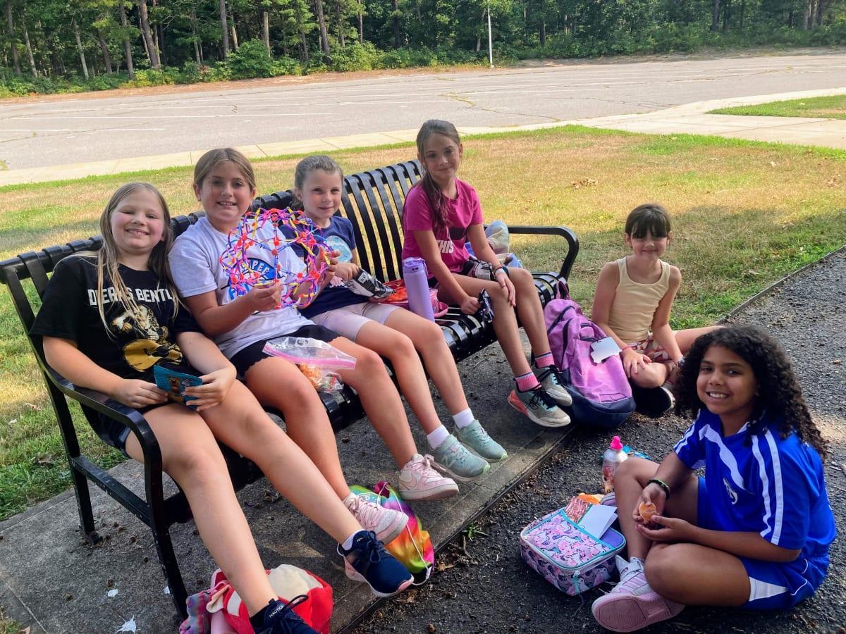 Girls on outside bench during snack time 