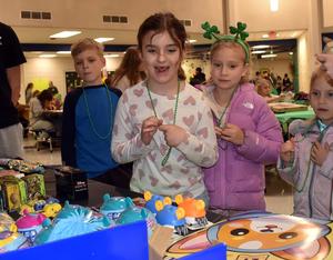 Three students looking at a table with prizes