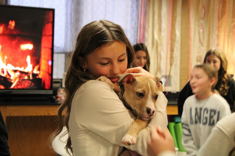 girl snuggling a puppy