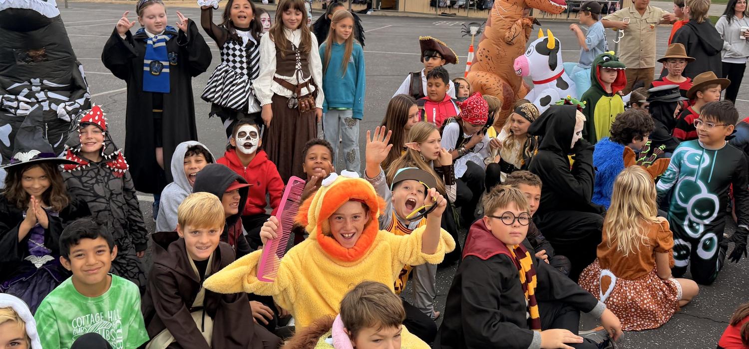 Students grouped together in various Halloween costumes on the blacktop