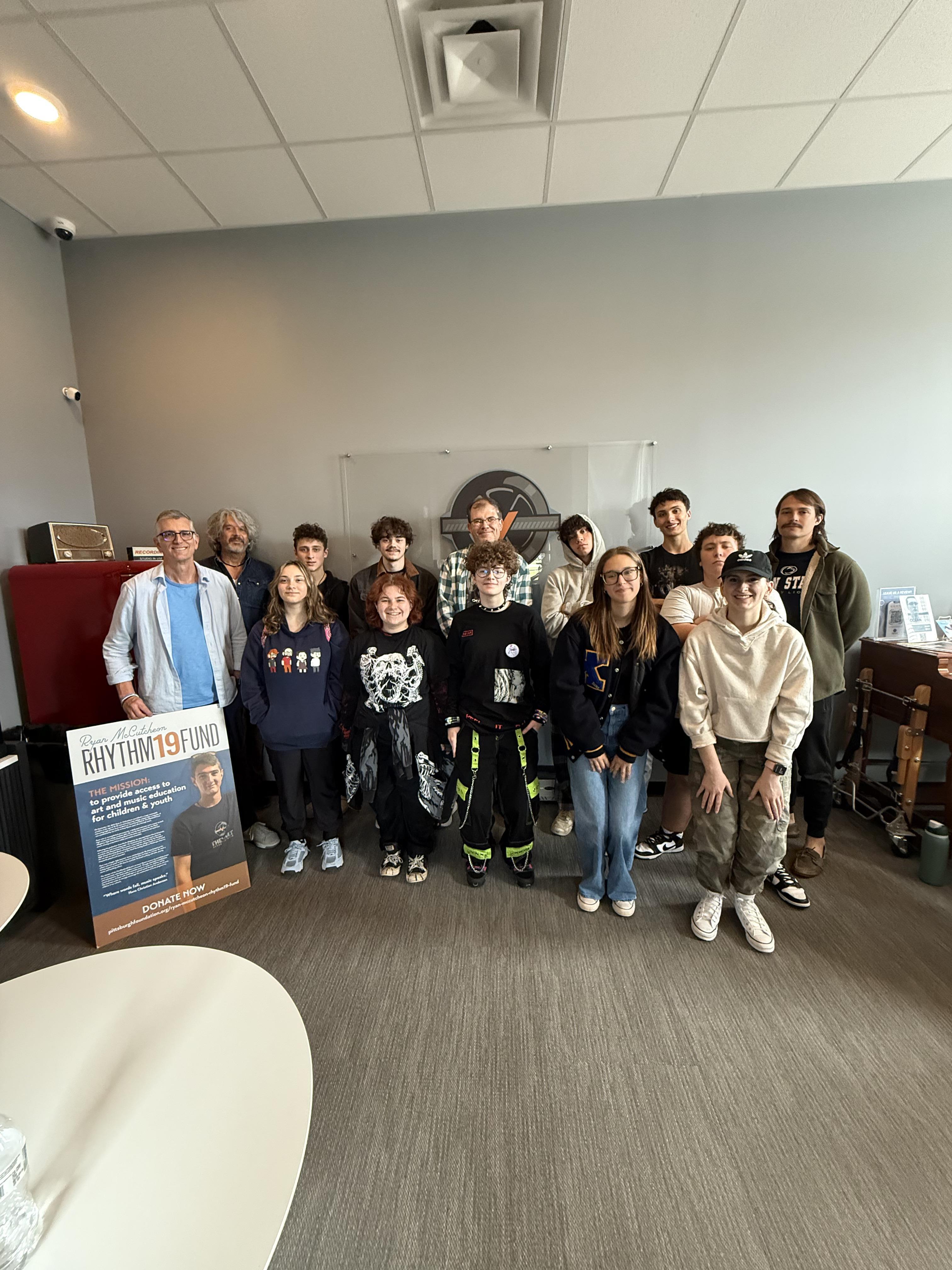 posed picture of a group of students and adults with a sign