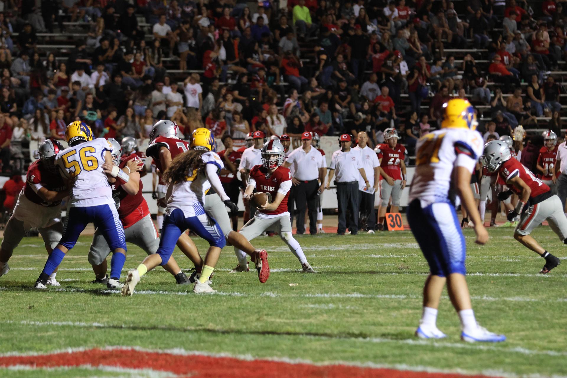 Varsity football players in action against Parlier 61