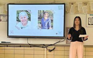 Student discussing images of two individuals during a presentation.
