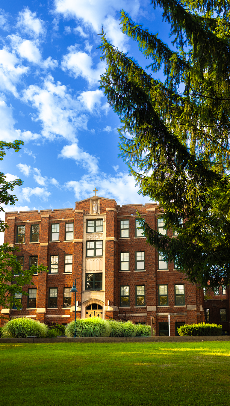 OLSH high school building with green grass lawn and blue sky