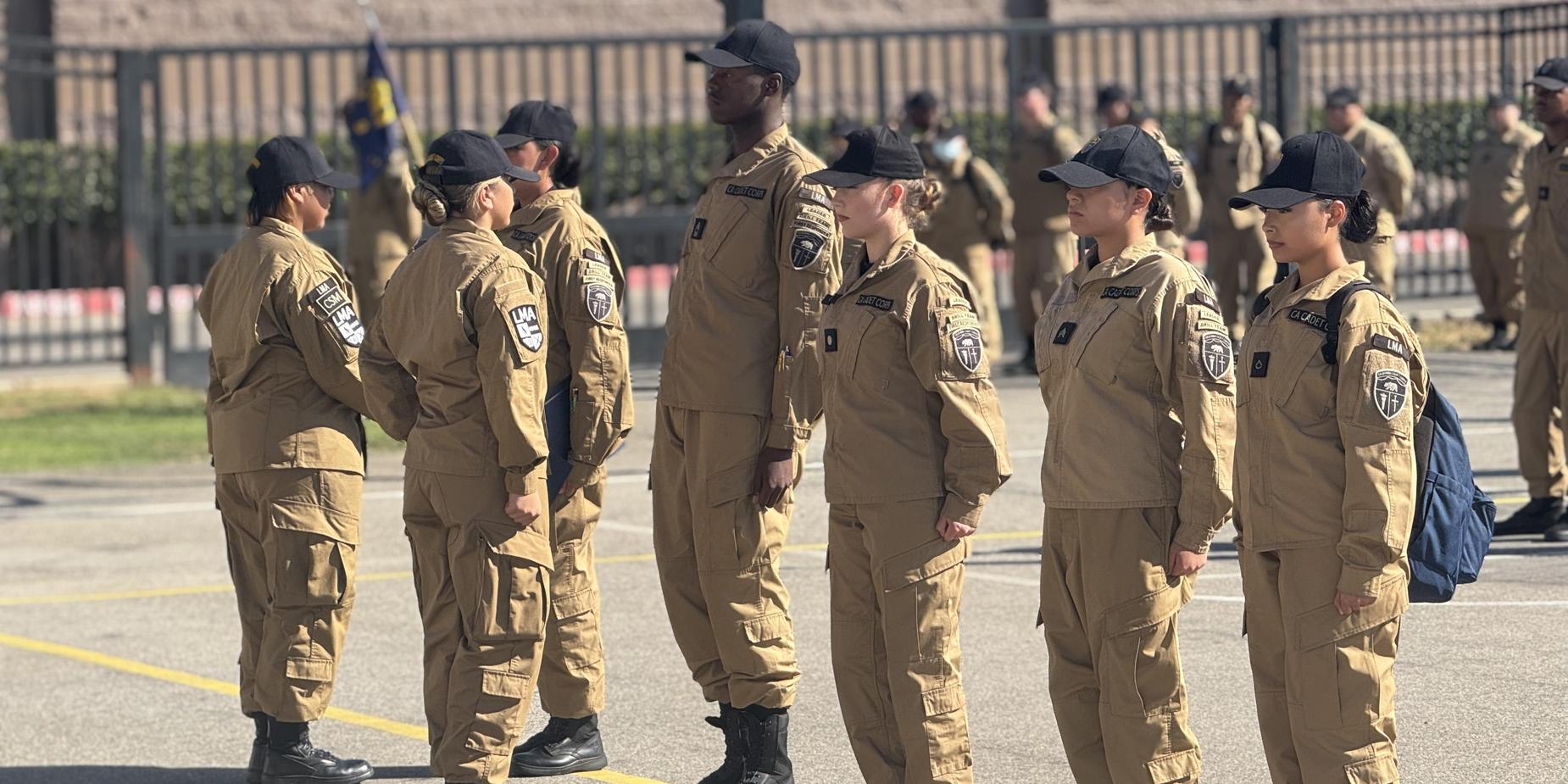 A lineup of uniformed individuals standing in formation outdoors.