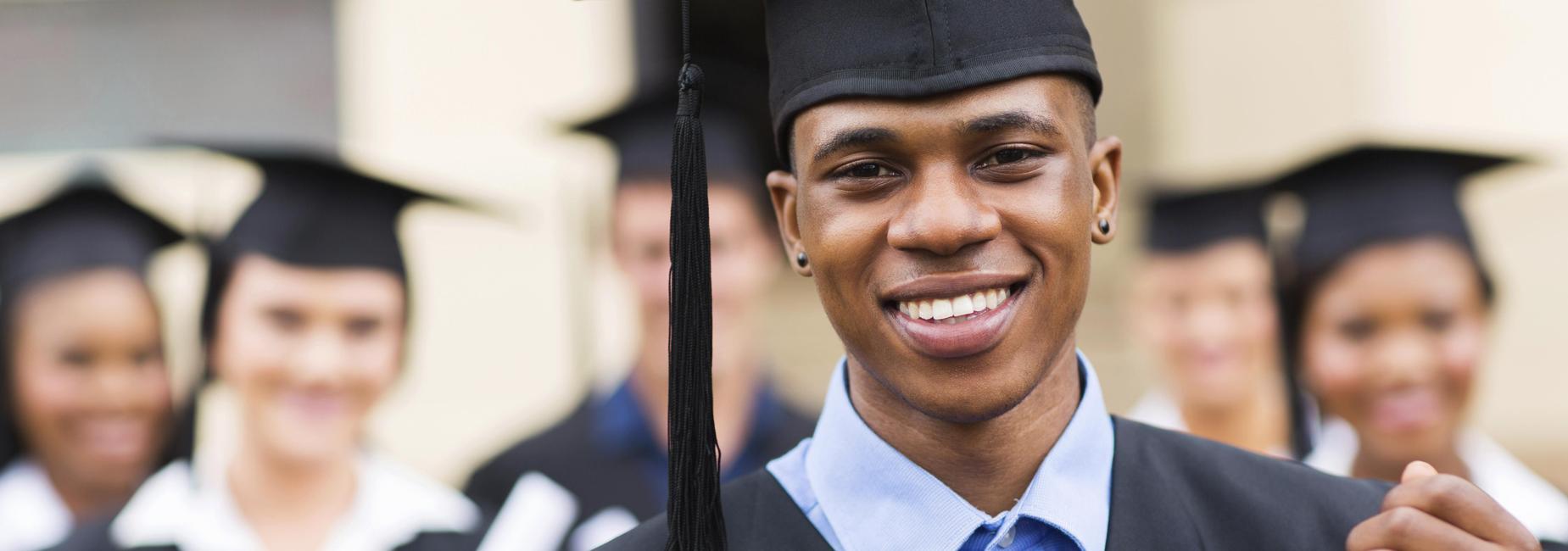 students in caps and gowns with diplomas