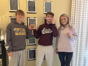 Students showing off their glow in the dark bracelets