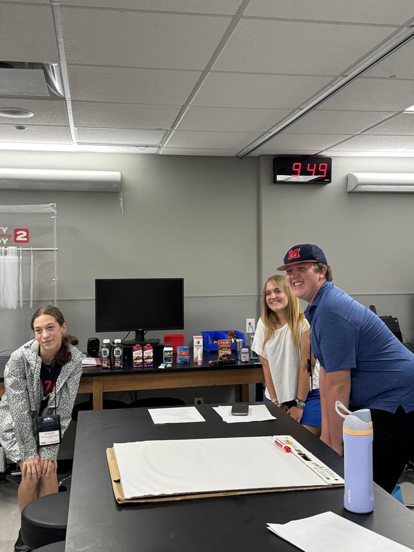 Ivy, Ellie, and another student pose for a picture in a classroom lab