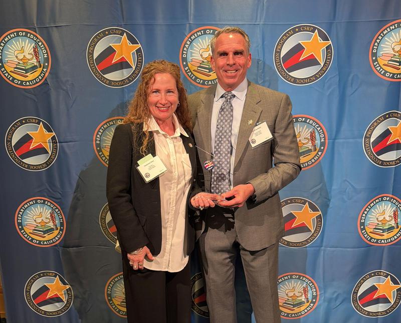 Principal Sosa and Superintendent Brauneisen with award.