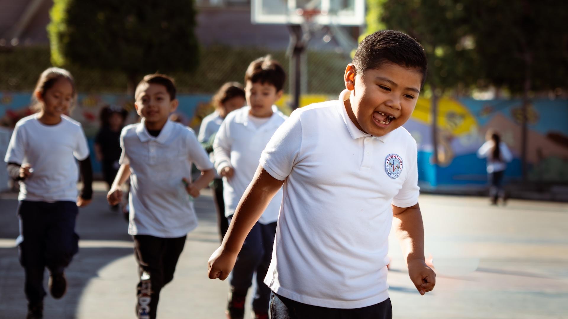Kids running energetically on a playground surface.