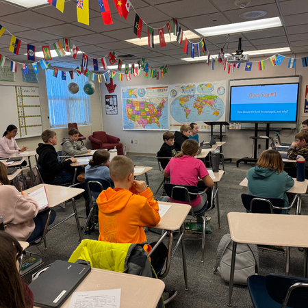 Classroom presentation with kids in desks around a ClearTouch Board.
