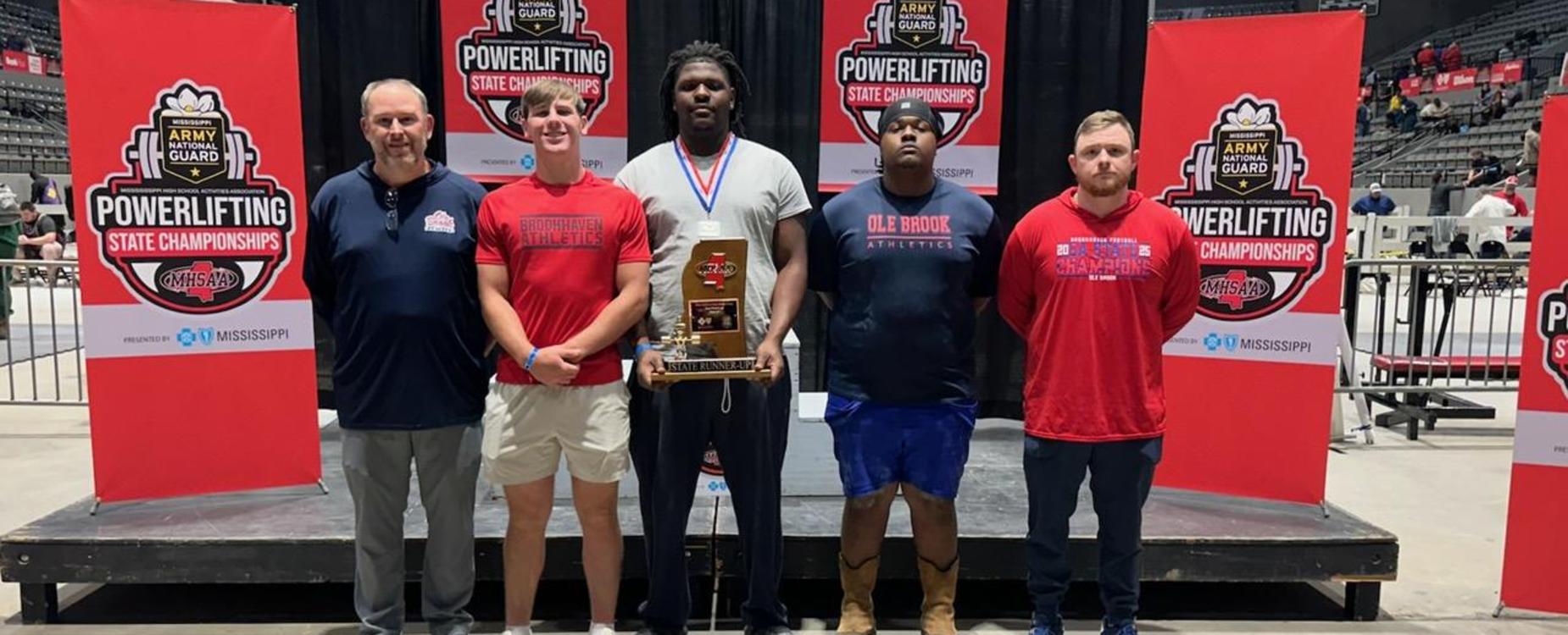 Five individuals stand together at a powerlifting championship event.