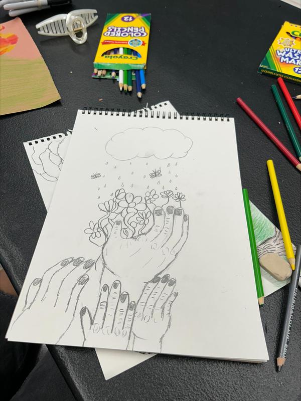student drawing of hands with flowers