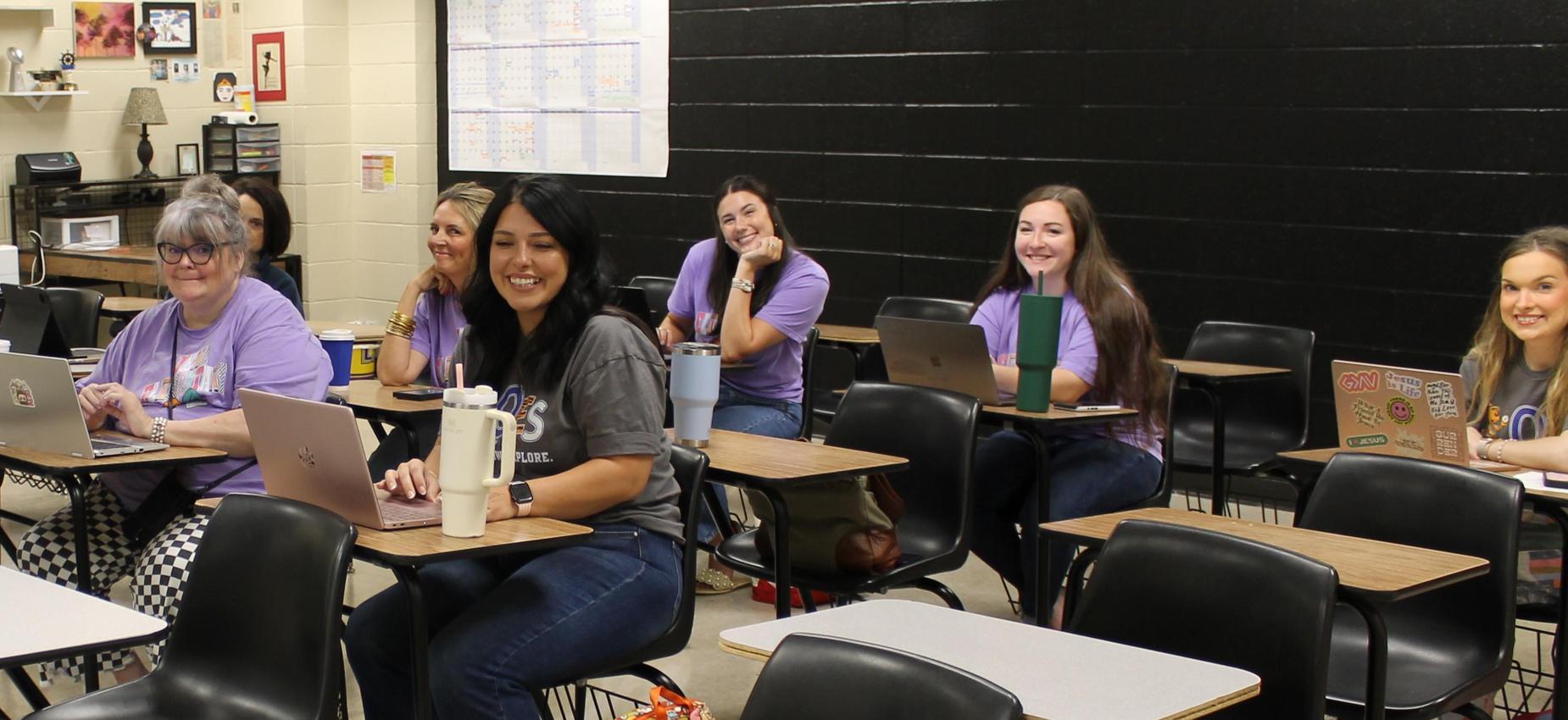 A group of students working on laptops in a classroom setting.