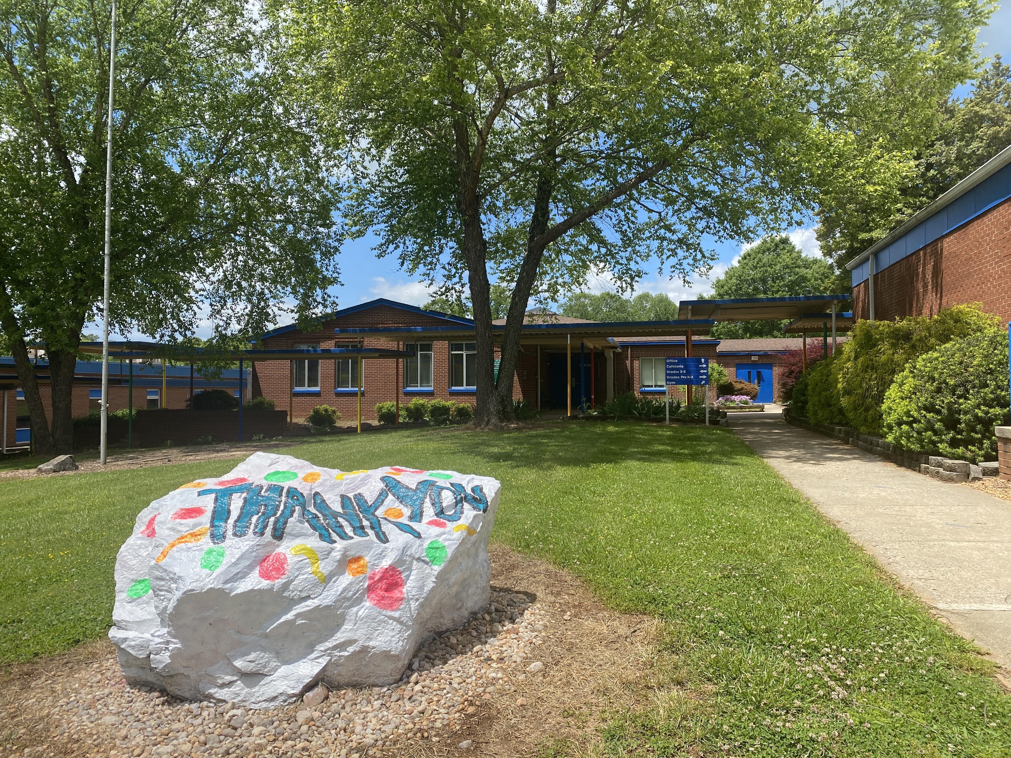 painted rock in front of school building