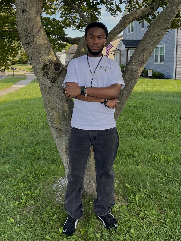 Cory Pressley standing in front of a tree, arms crossed.