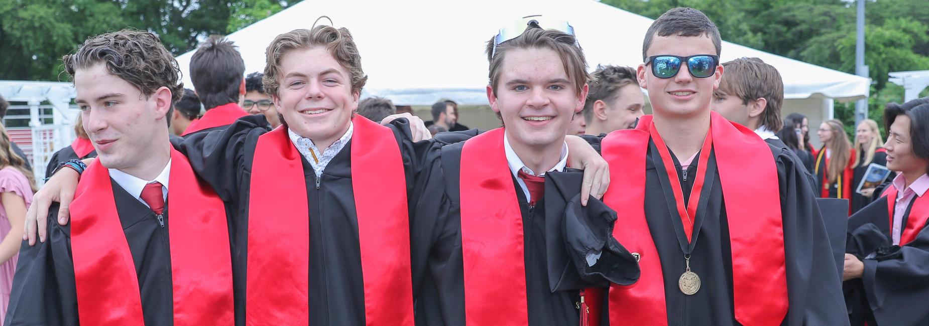 4 male graduates smiling