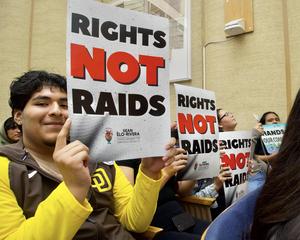 Students hold "Rights Not Raids" signs