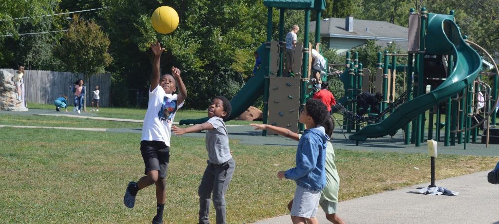 boy shoots a basket while 3 boys defend