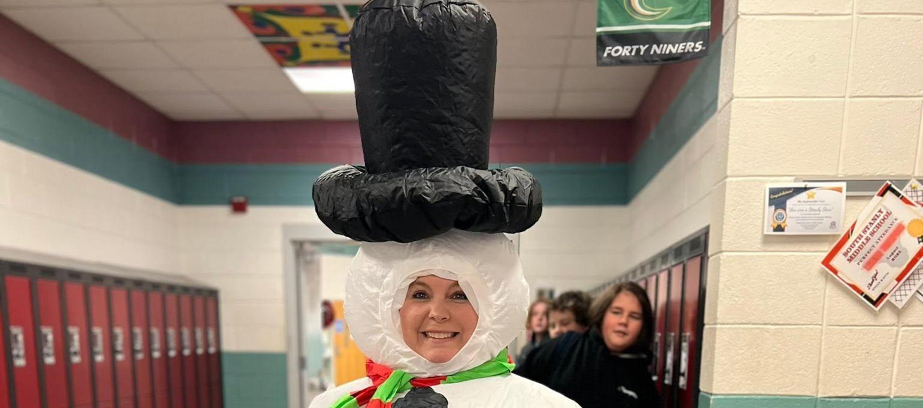 Person dressed as a snowman in a school hallway.