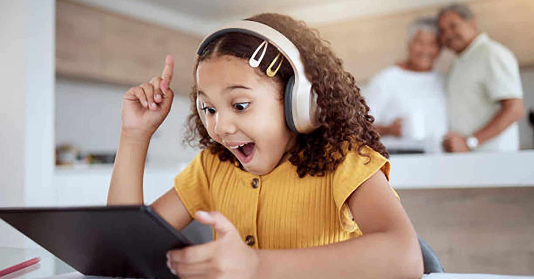 Elementary Girl at Laptop Parents in Background