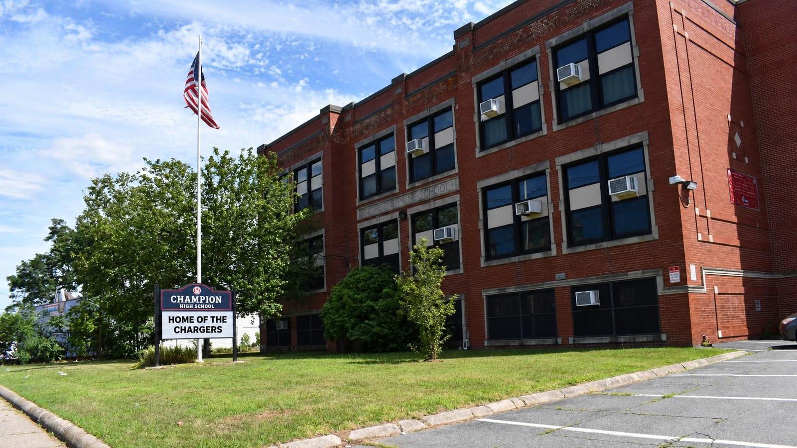 Exterior of school building with flagpole and sign