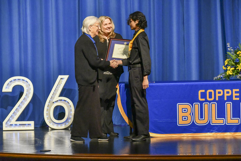 Male student shaking a woman's hand and receiving an award