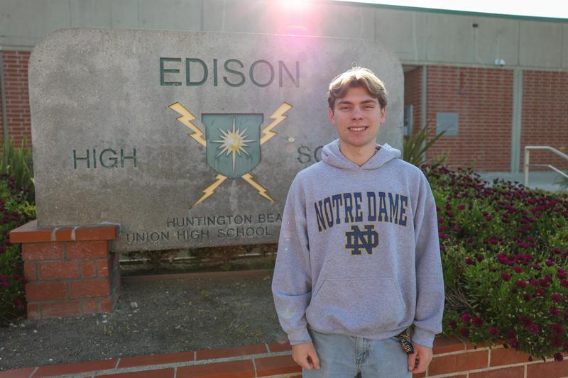 senior student at edison standing in front of edison high school signage