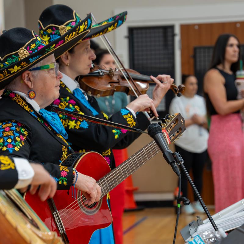 Musicians in traditional attire playing instruments at a performance.